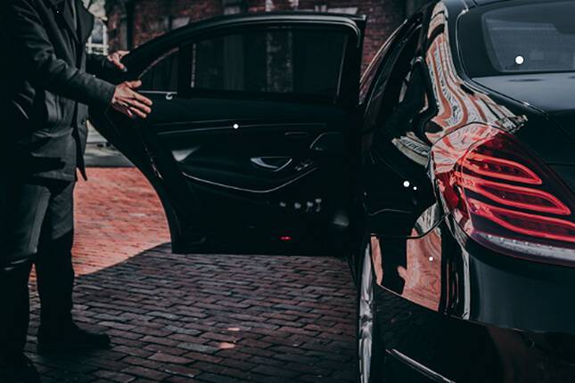 chauffeur open door of a luxury car