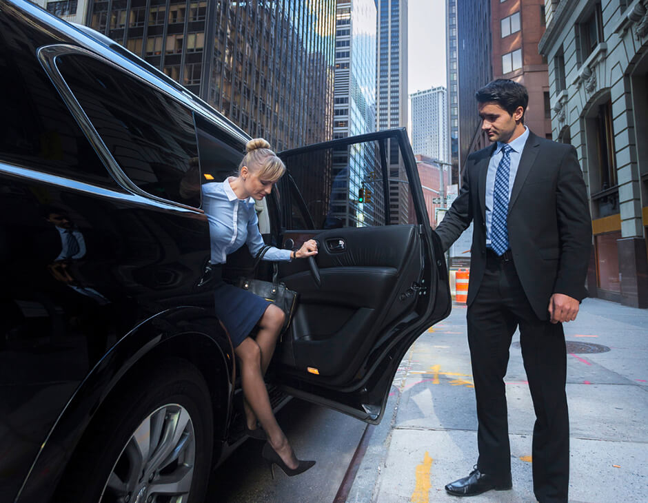 chauffeur opens door for a business lady | private chauffeur service
